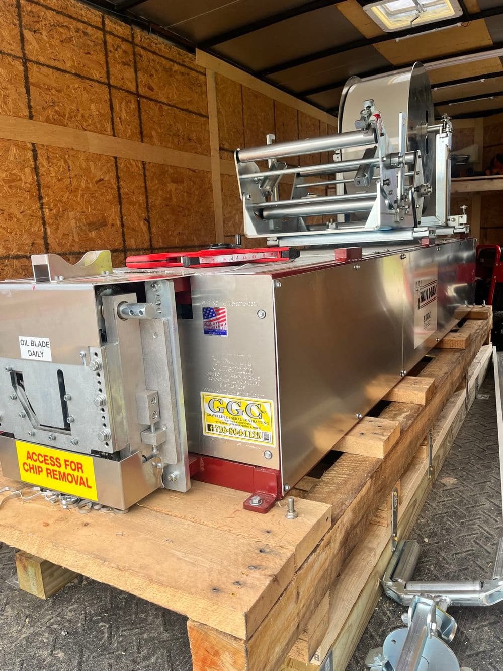 Industrial machinery for chip removal, mounted on wooden pallet in transport trailer.