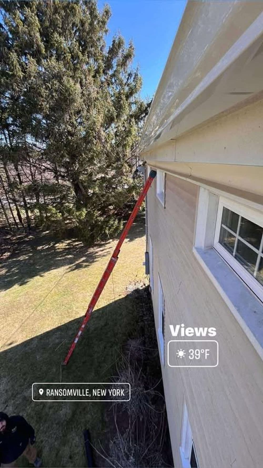 Ladder resting against a house in Ransomville, New York, with sunny weather at 39°F.
